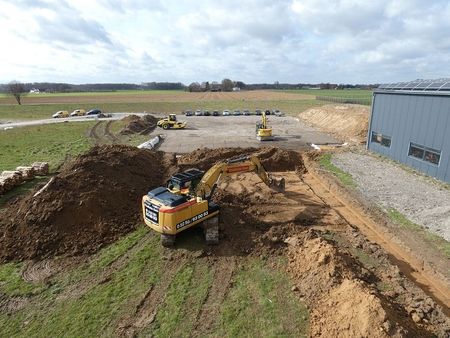 Baustelle mit einem Traktor und einem Bagger, die für Erdarbeiten und Bauprojekte eingesetzt werden.